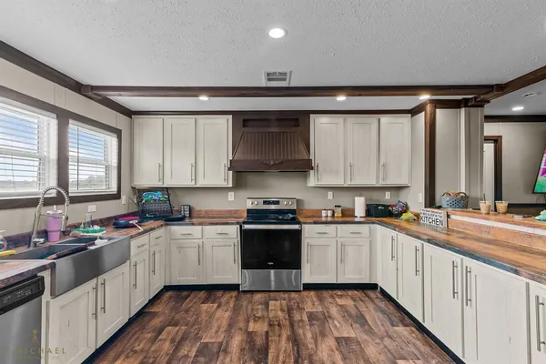 a kitchen with a sink stove top oven and cabinets