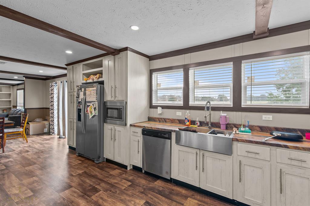 4638 Benton Road Bossier City, LA 71111 - Photo 14 of 34 a kitchen with stainless steel appliances granite countertop a refrigerator a sink dishwasher a stove and white cabinets with wooden floor
