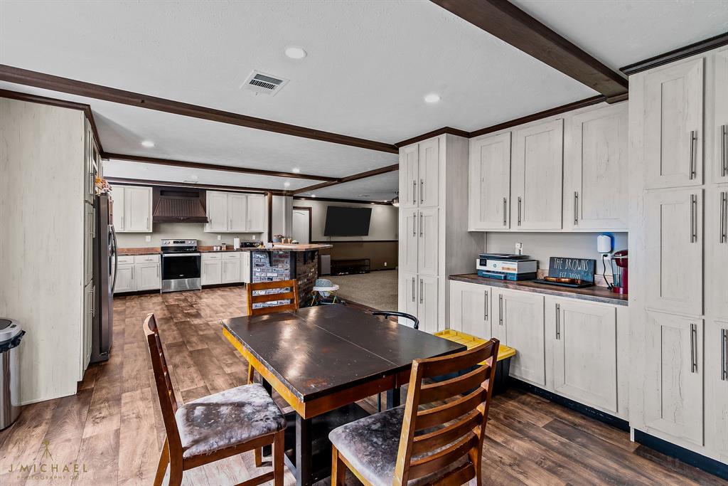 4638 Benton Road Bossier City, LA 71111 - Photo 17 of 34 a kitchen with stainless steel appliances granite countertop a stove a sink dishwasher and a refrigerator with wooden floor