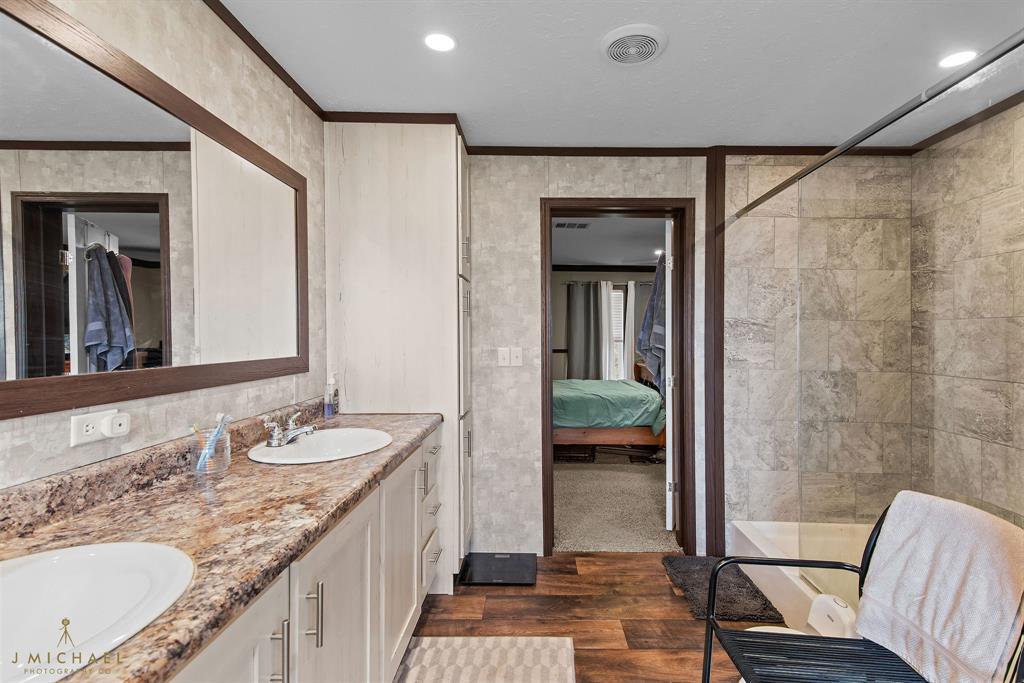 4638 Benton Road Bossier City, LA 71111 - Photo 31 of 34 a bathroom with a granite countertop sink a mirror and a shower