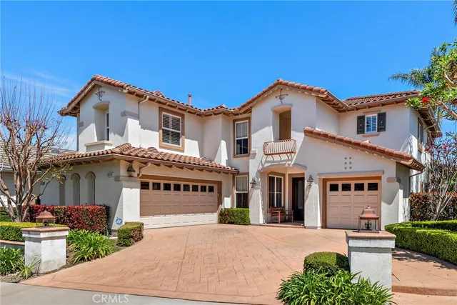 a view of a white house with a small yard and plants