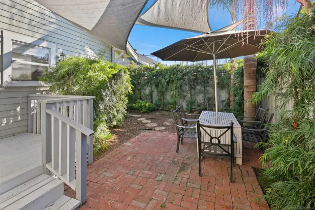 a view of a patio with table and chairs under an umbrella