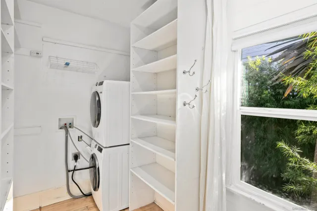 a view of walk in closet with clothes and window