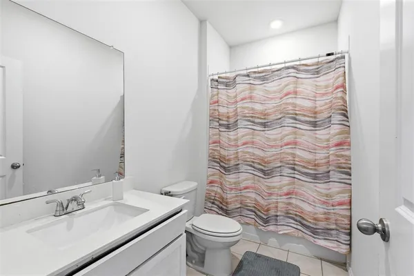 a bathroom with a shower curtain sink and a toilet