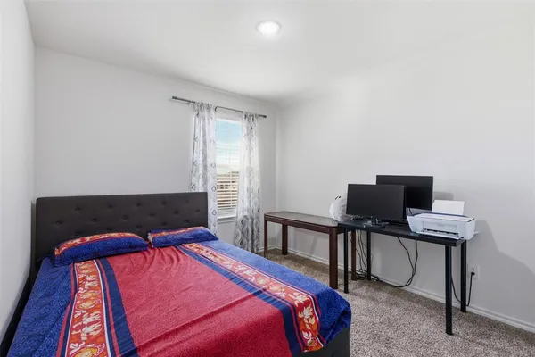 a bedroom with a bed and a desk