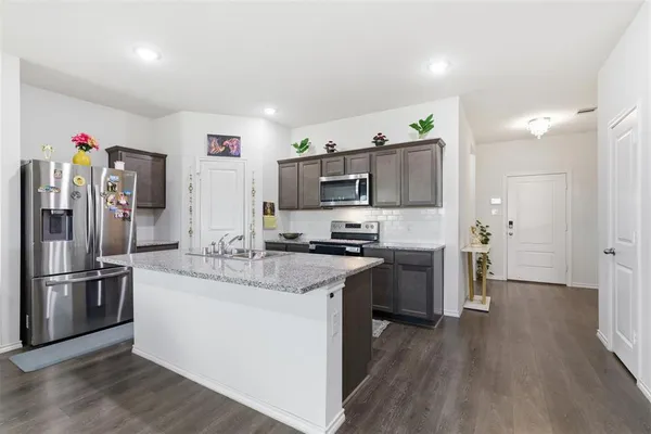 a kitchen with stainless steel appliances granite countertop a refrigerator stove and sink