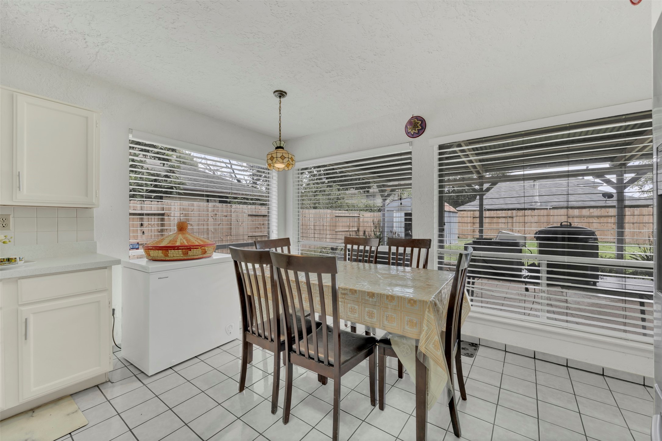 15619 Beechnut Street Houston, TX 77083 - Photo 13 of 29 Sun-filled breakfast area with wrap-around windows offering peaceful backyard views and direct access to the covered patio.