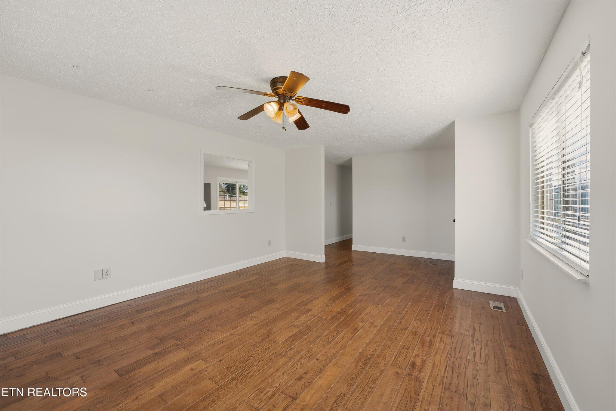 5413 Pryor Road Maryville, TN 37804 - Photo 9 of 33 an empty room with wooden floor ceiling fan and windows