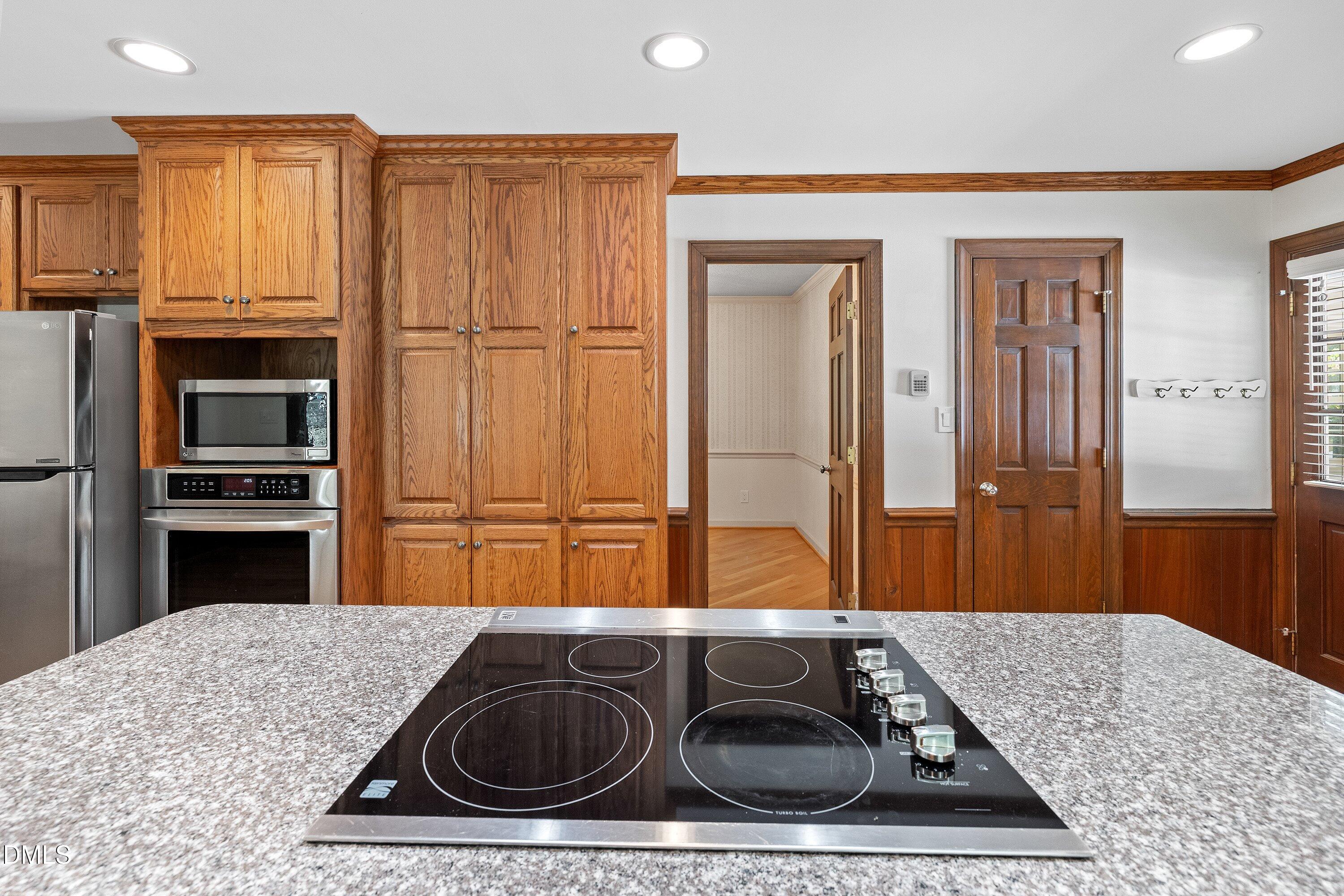 8133 Holly Forest Road Wake Forest, NC 27587 - Photo 17 of 50 a kitchen with kitchen island a sink stainless steel appliances granite countertop a granite counter tops and a view of living room