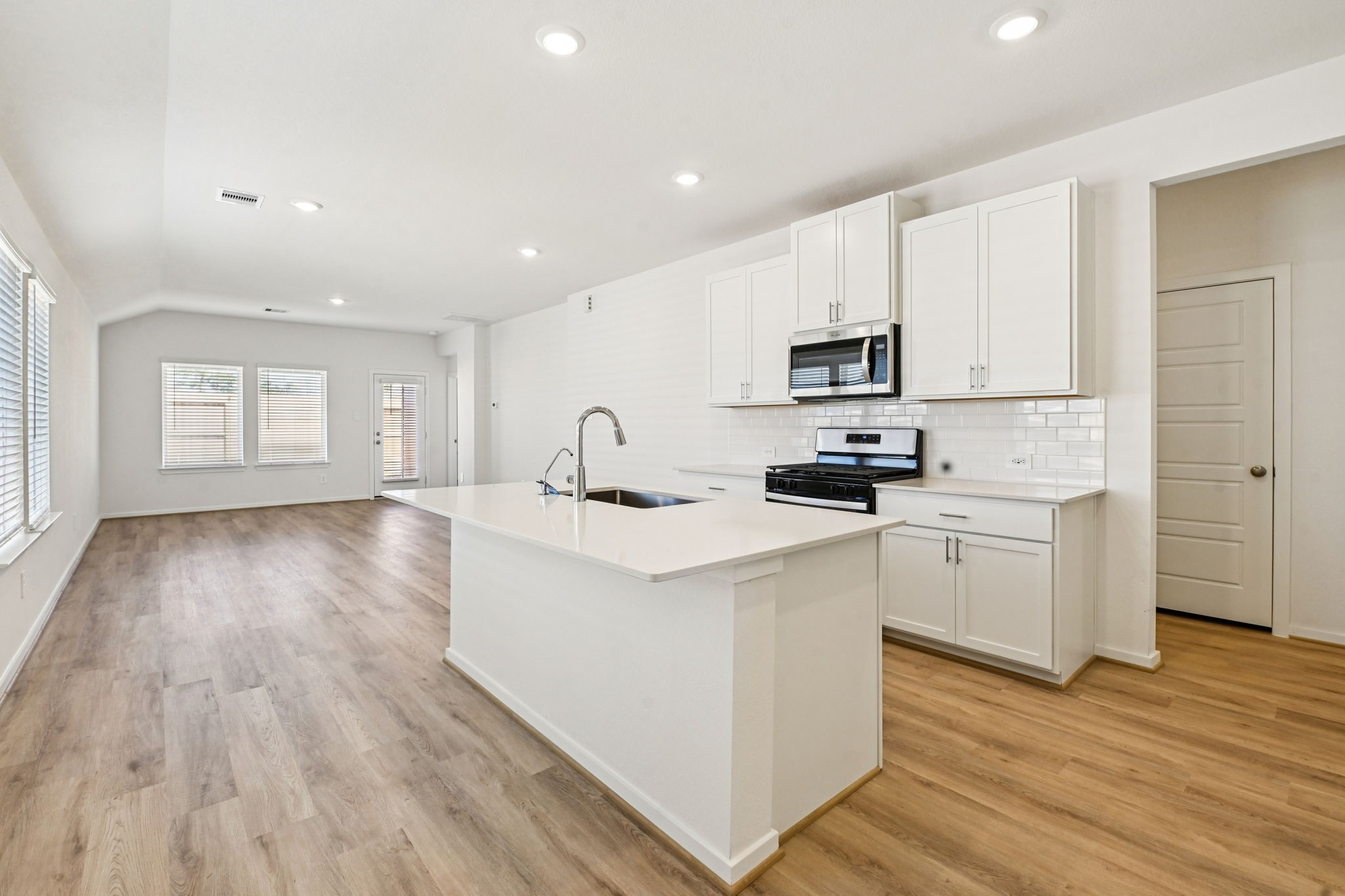 14147 Granger Pointe Lane Conroe, TX 77302 - Photo 11 of 35 a kitchen with a sink a counter top space and cabinets