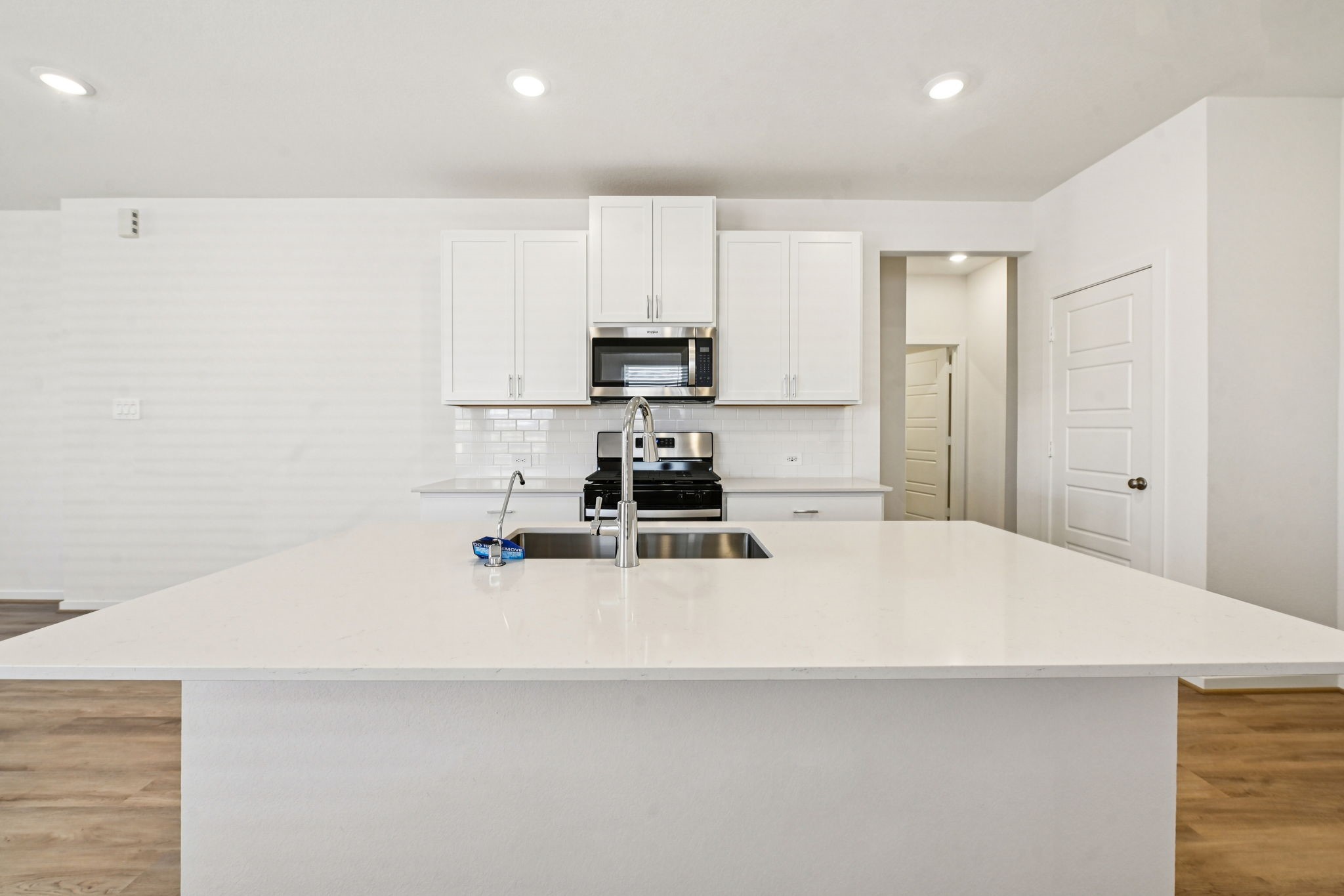14147 Granger Pointe Lane Conroe, TX 77302 - Photo 12 of 35 a kitchen with kitchen island a stove a sink and a refrigerator