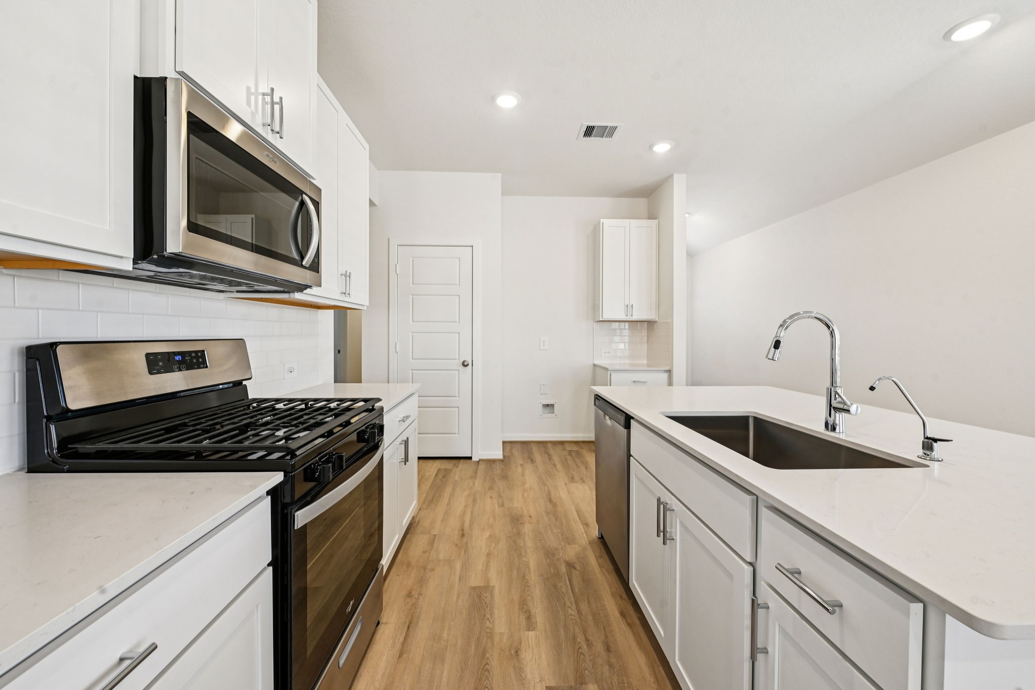 14147 Granger Pointe Lane Conroe, TX 77302 - Photo 13 of 35 a kitchen with stainless steel appliances granite countertop a sink stove and microwave
