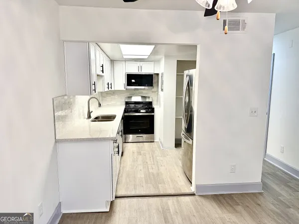 a kitchen with stainless steel appliances kitchen island granite countertop a refrigerator and a sink