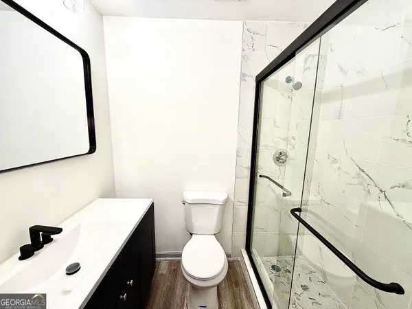a white toilet sitting next to a bathroom sink and a mirror