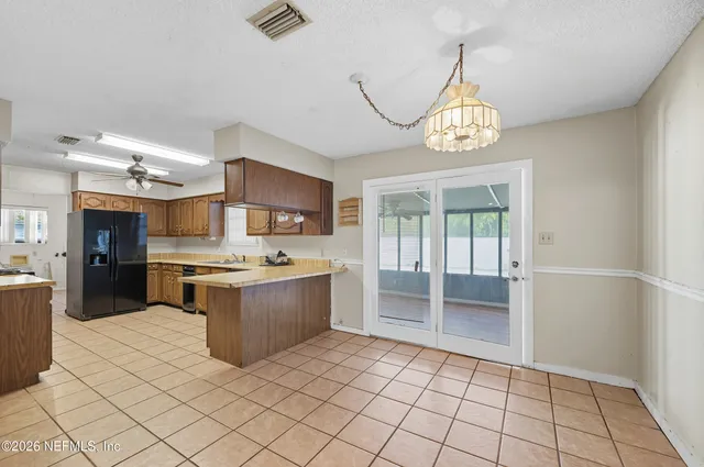 a large kitchen with a large counter space a sink appliances and cabinets