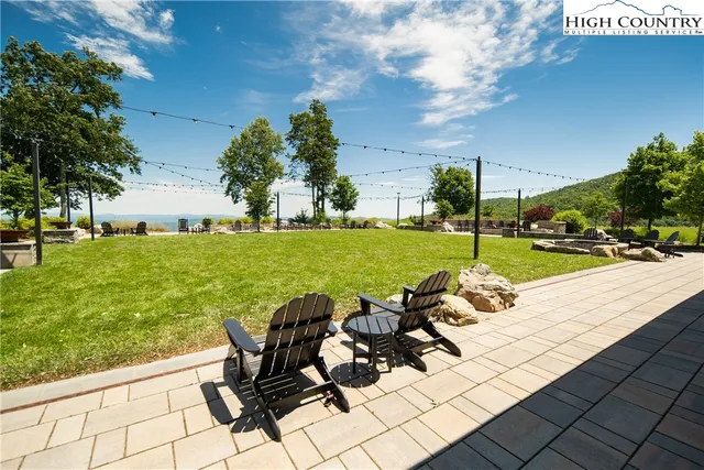 a view of a swimming pool with a patio and a yard