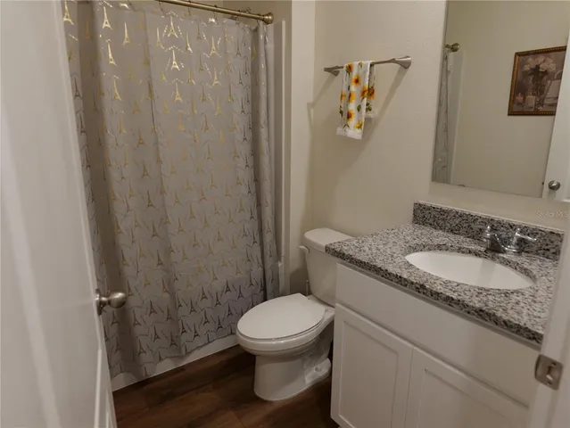 a bedroom with a bed and a lamp on the dresser