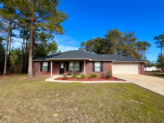 a front view of a house with a yard and trees