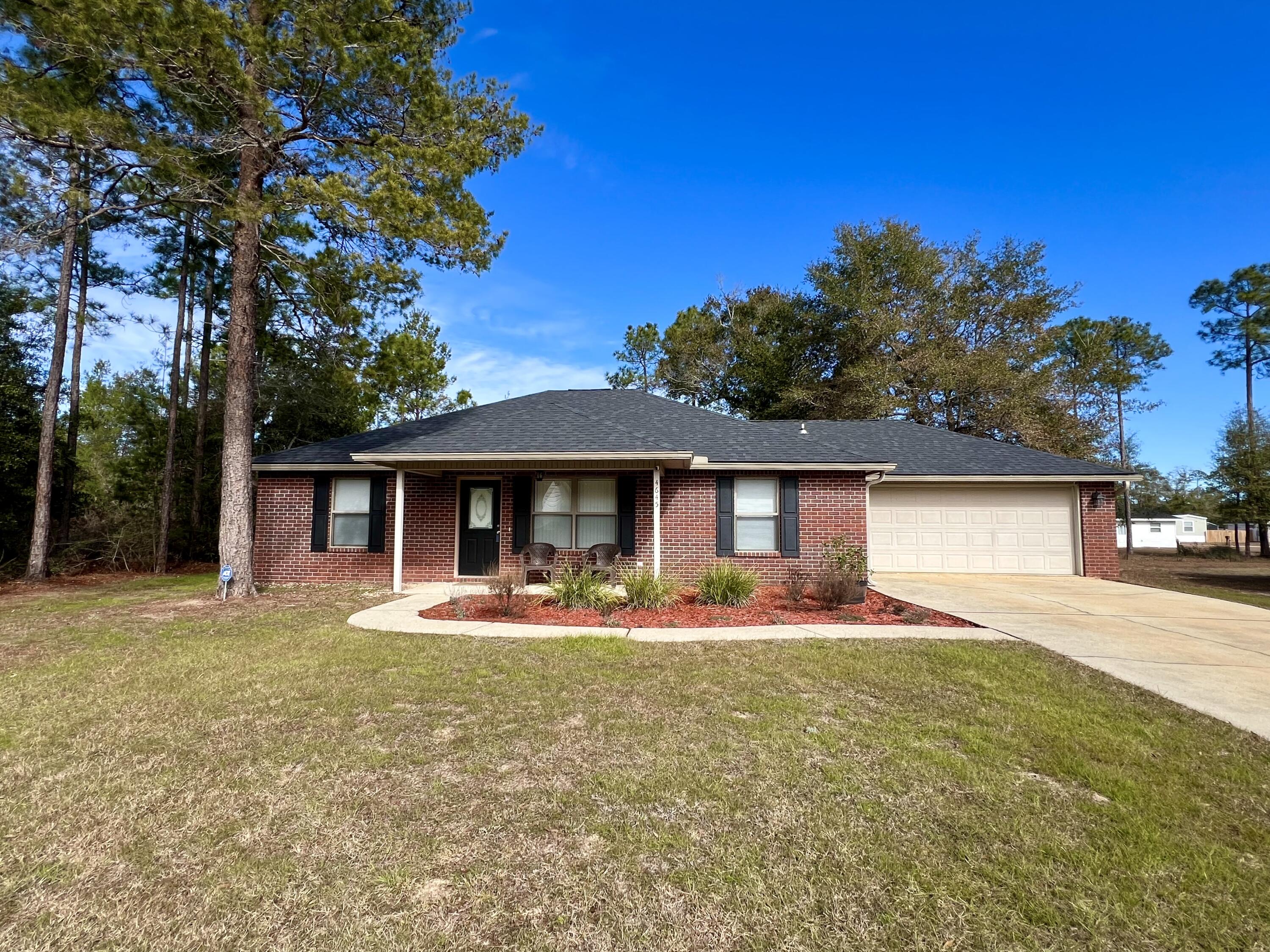 4645 Dove Way Crestview, FL 32539 - Photo 1 of 21 a front view of a house with a yard and trees