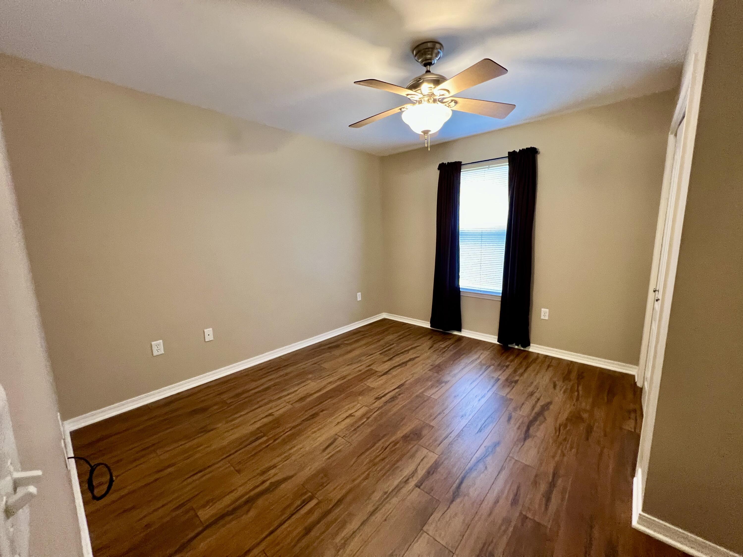 4645 Dove Way Crestview, FL 32539 - Photo 13 of 21 a view of an empty room with a window and wooden floor
