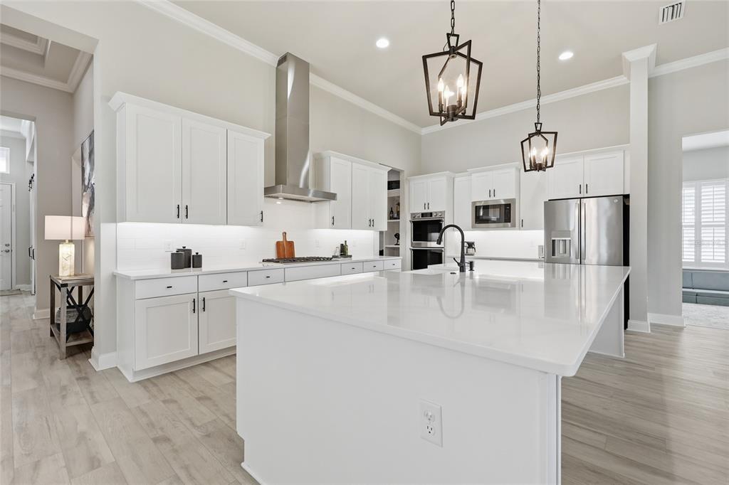 10776 Southwest 36th Place Gainesville, FL 32608 - Photo 6 of 44 a kitchen with kitchen island a white counter top space cabinets and stainless steel appliances