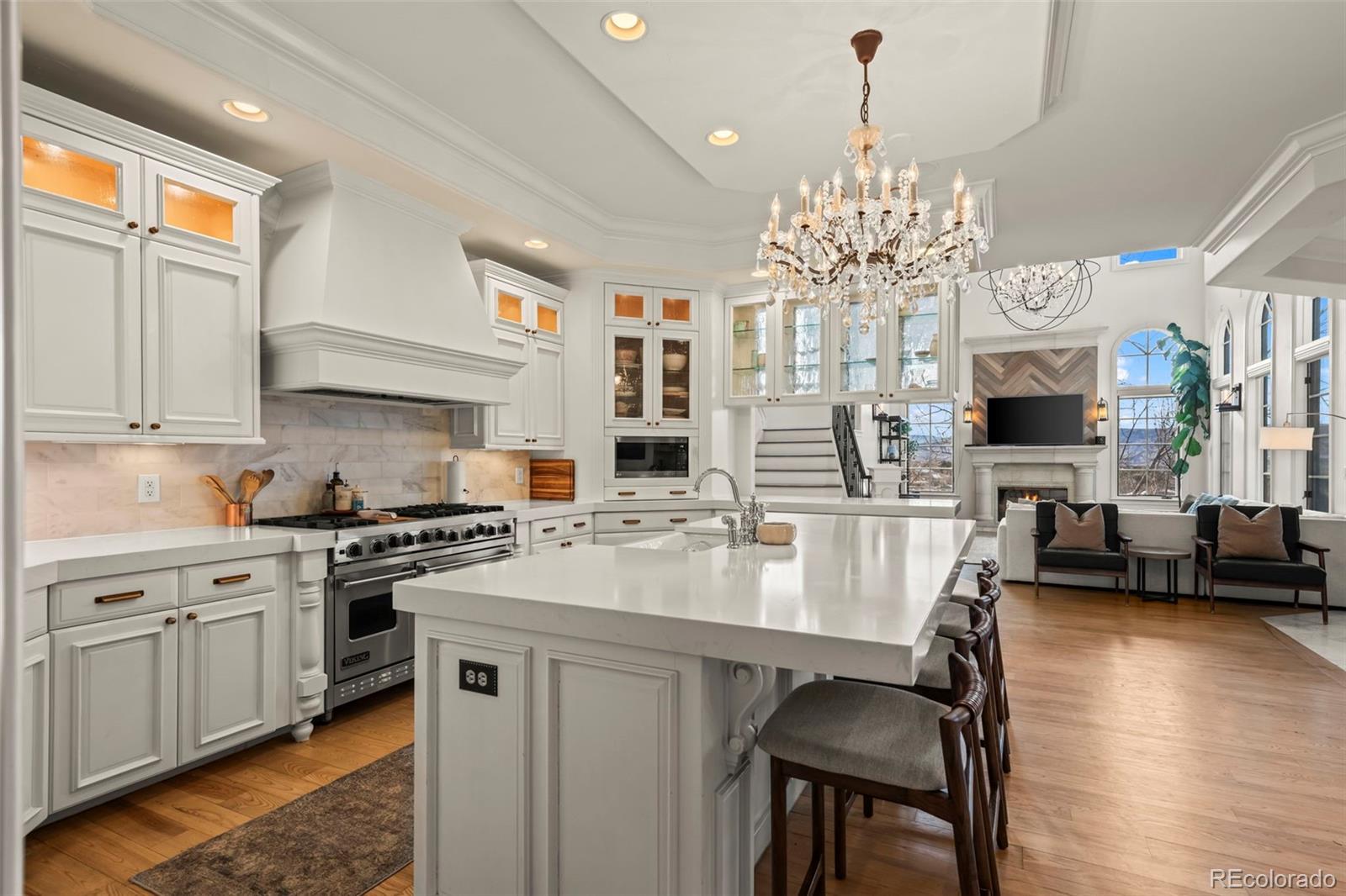 1012 Michener Way Highlands Ranch, CO 80126 - Photo 12 of 50 a kitchen with stainless steel appliances granite countertop a stove top oven a sink dishwasher and white cabinets with wooden floor