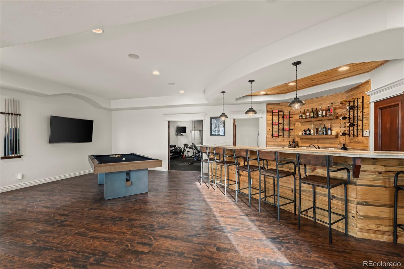 1012 Michener Way Highlands Ranch, CO 80126 - Photo 35 of 50 a living room with furniture a flat screen tv and kitchen view