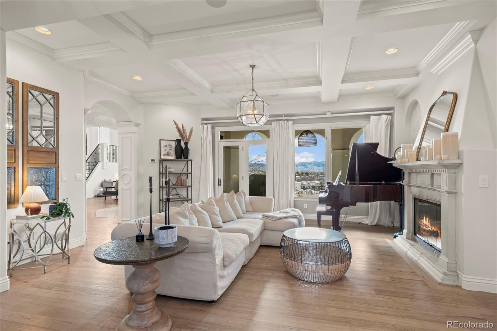 1012 Michener Way Highlands Ranch, CO 80126 - Photo 6 of 50 a living room with fireplace furniture and a chandelier