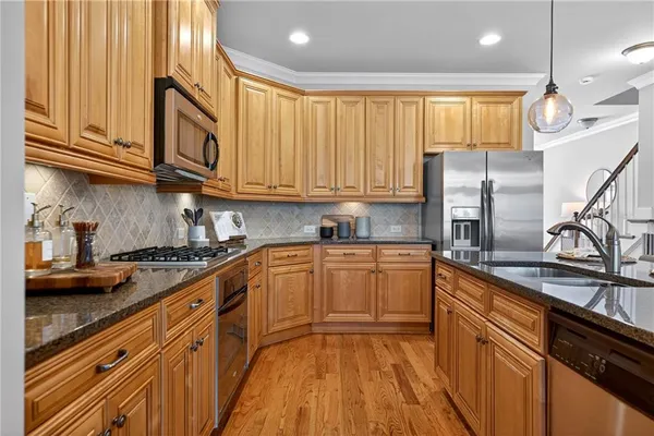 a kitchen with stainless steel appliances granite countertop a sink stove and refrigerator