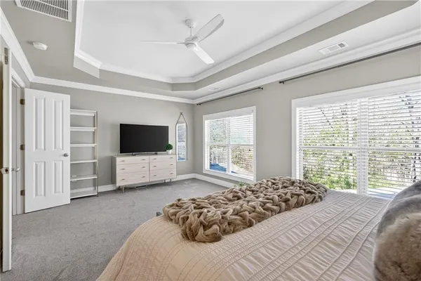a spacious bedroom with a bed and a television