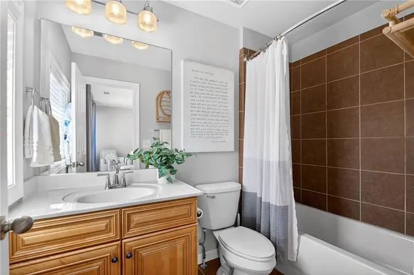 a bathroom with a sink a toilet a mirror and shower