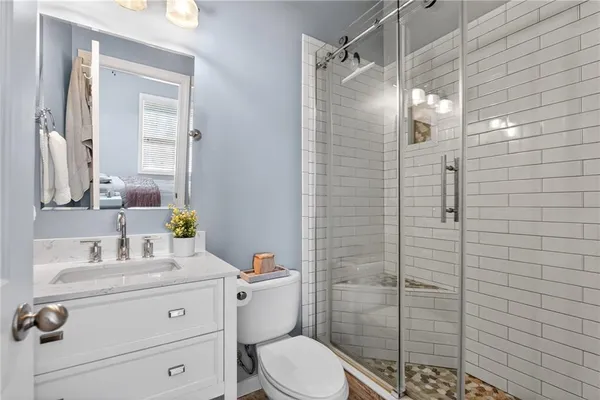 a bathroom with a sink toilet vanity and shower