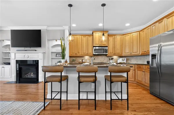 a kitchen with stainless steel appliances granite countertop a stove a sink a microwave a dining table and chairs
