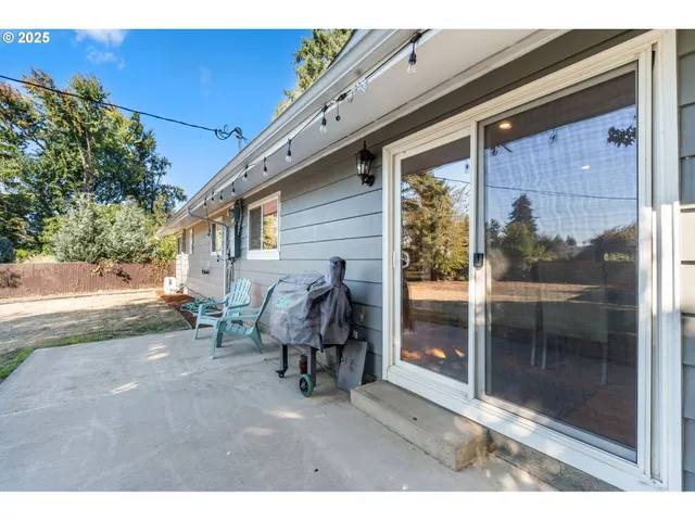 a backyard of a house with barbeque oven table and chairs