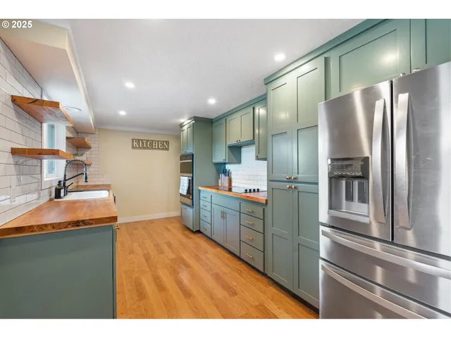 a kitchen with stainless steel appliances granite countertop a refrigerator and a sink