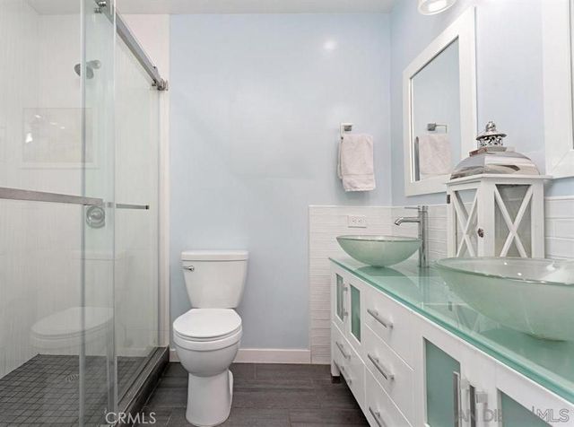 a bathroom with a granite countertop sink a toilet and a mirror