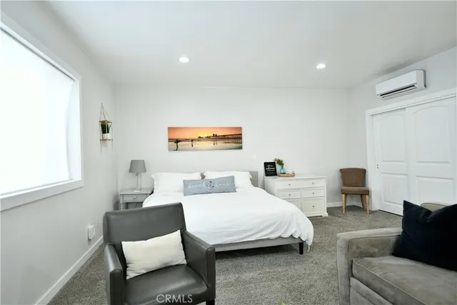 a bedroom with a bed a couch and a window