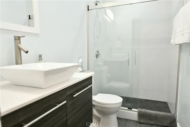 a bathroom with a sink a toilet and shower