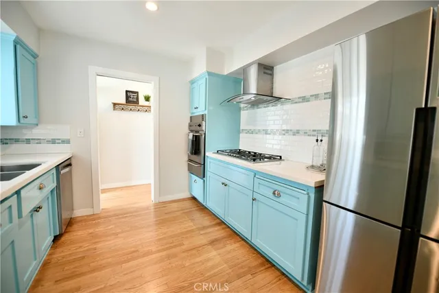 a kitchen with stainless steel appliances granite countertop a refrigerator a stove and a sink