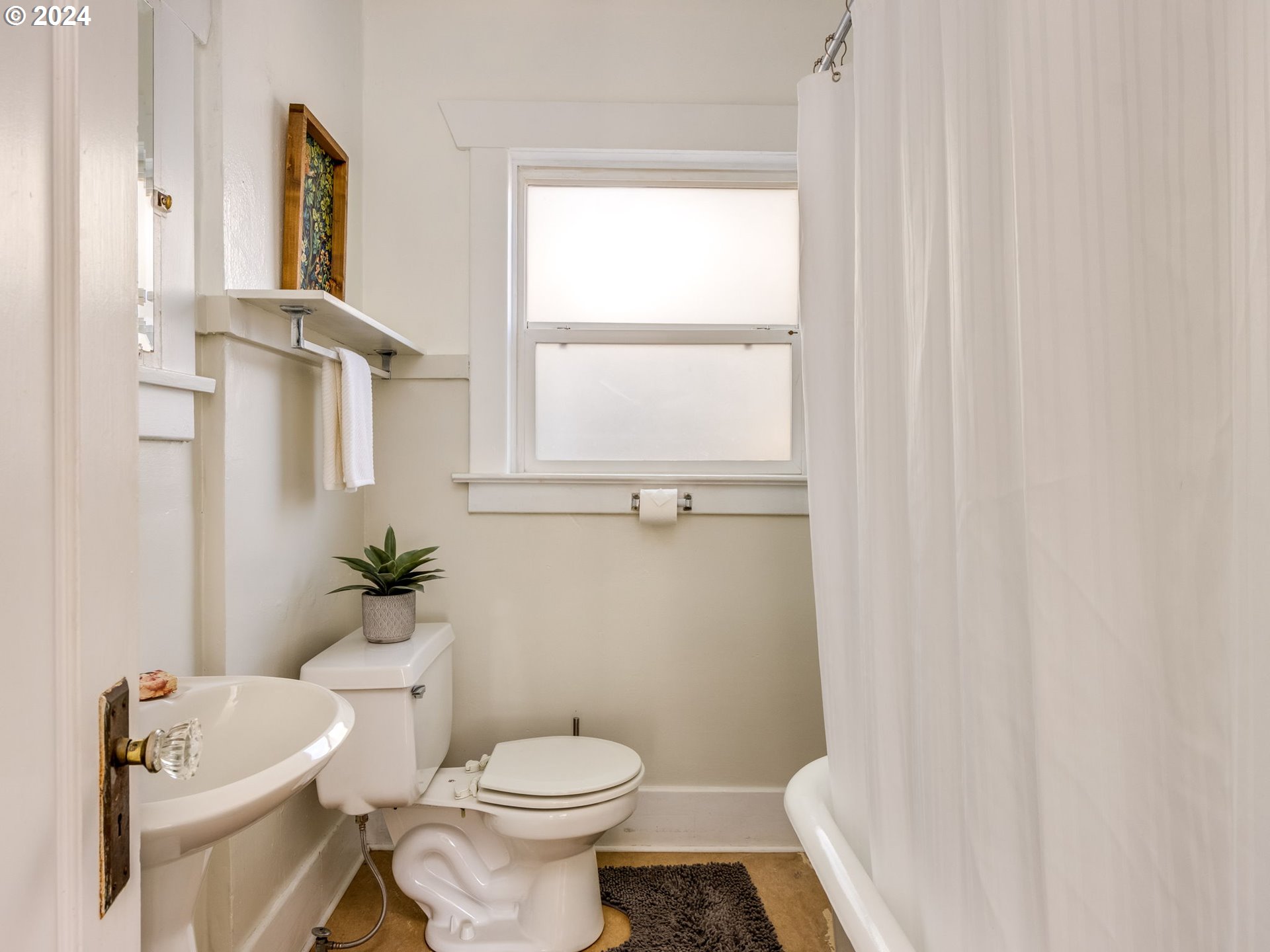 2834 Northeast 64th Avenue Portland, OR 97213 - Photo 22 of 27 a white toilet sitting next to a bathroom sink and a window