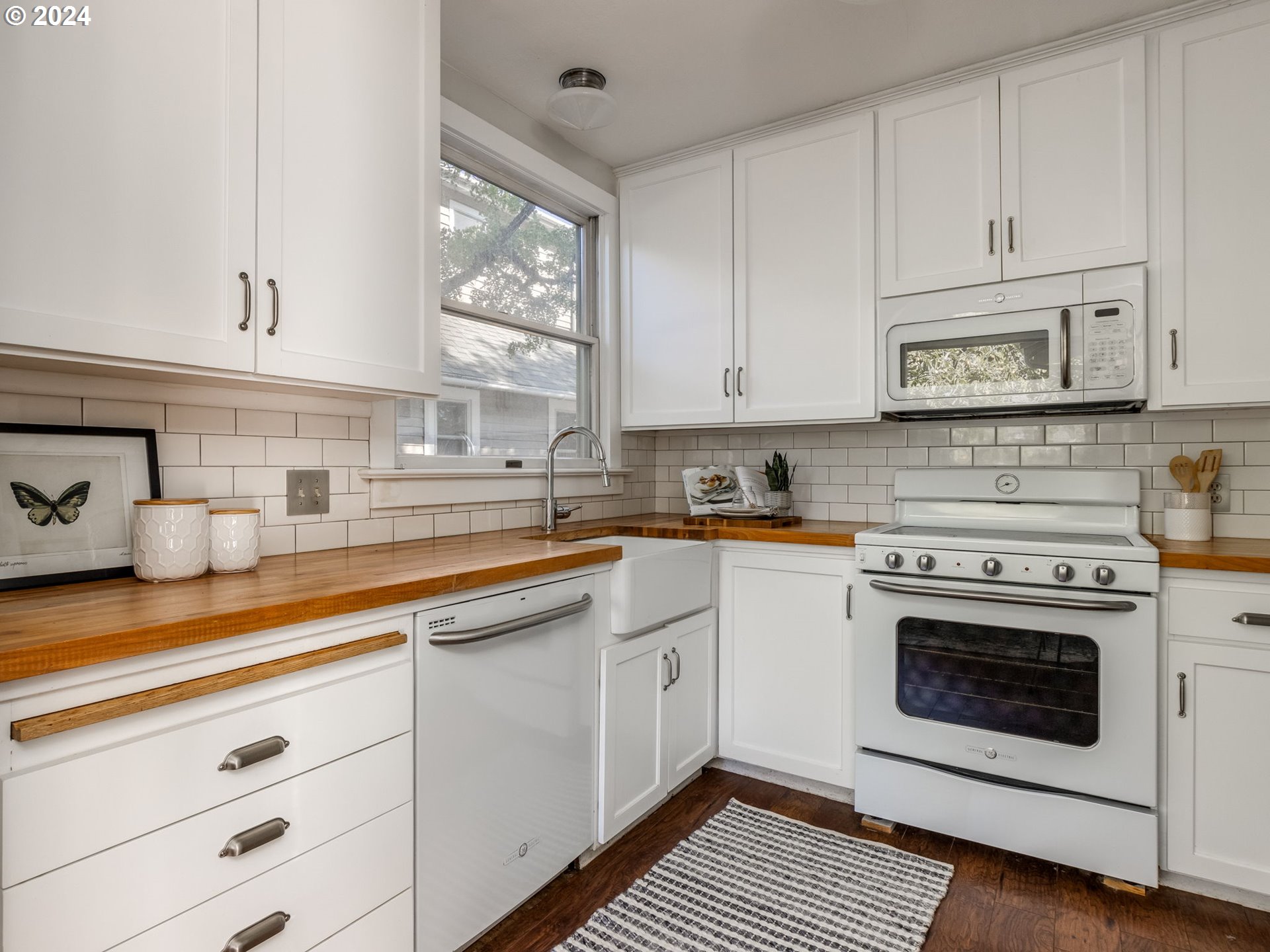2834 Northeast 64th Avenue Portland, OR 97213 - Photo 9 of 27 a kitchen with stainless steel appliances granite countertop a stove a sink and white cabinets