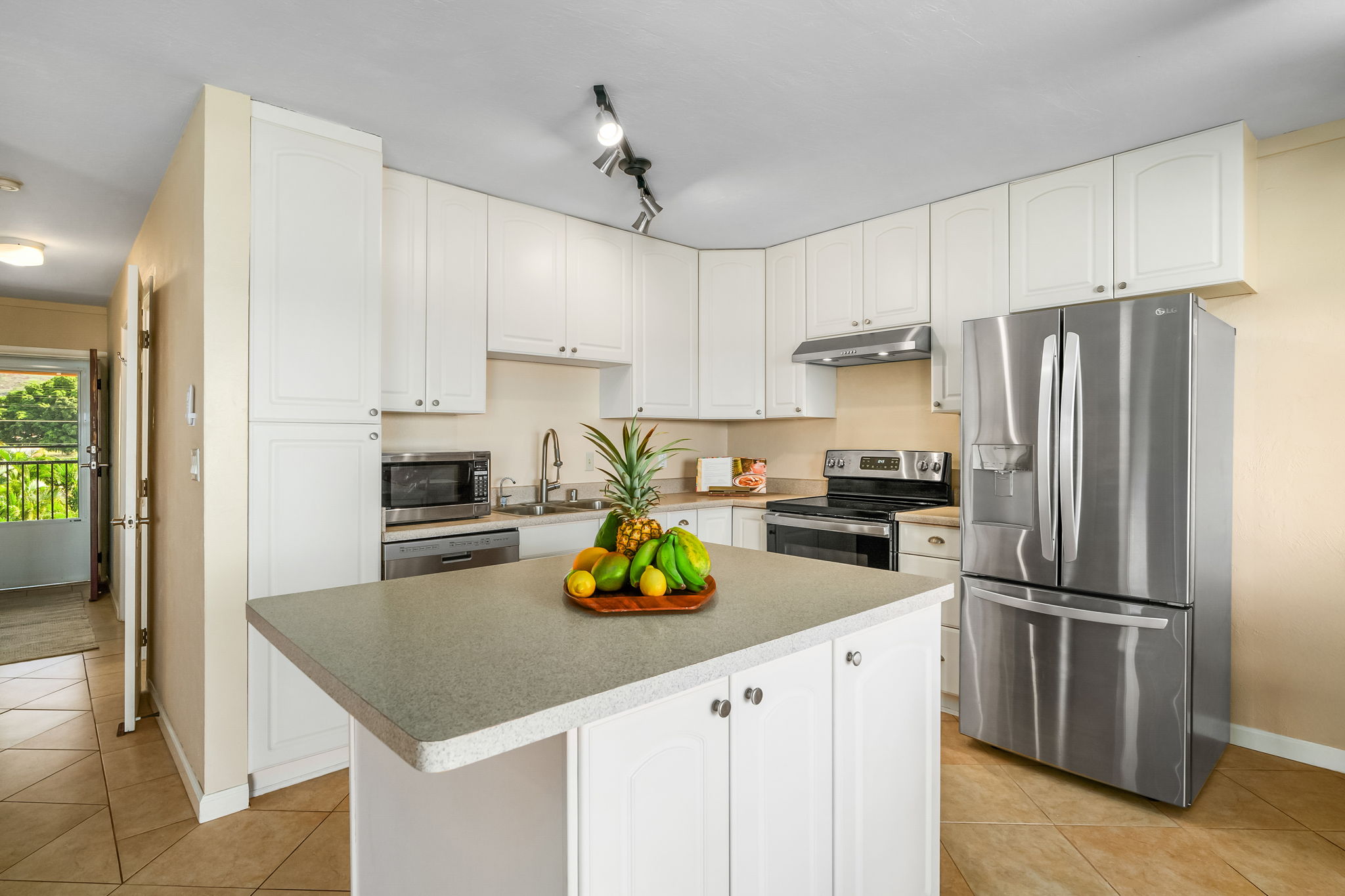 4451 Moana Road, Unit 309 Waimea, HI 96796 - Photo 5 of 21 a kitchen with refrigerator cabinets and wooden floor