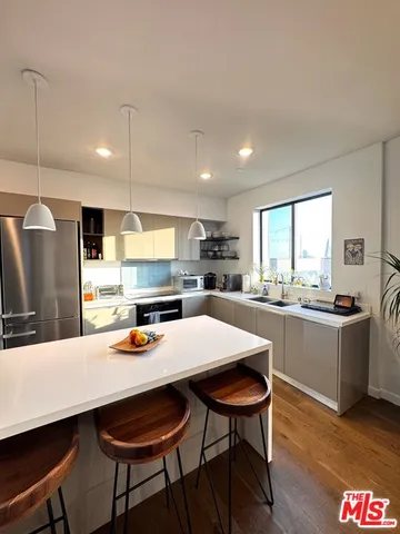 a kitchen with a dining table chairs sink and wooden floor