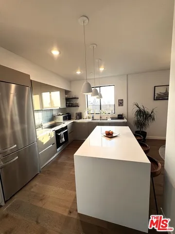 a kitchen with kitchen island a sink stainless steel appliances and window