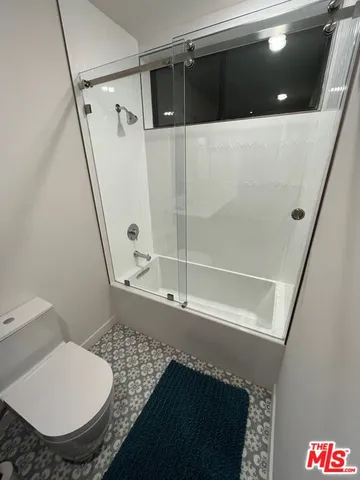 a spacious bedroom with a bed and wooden floor