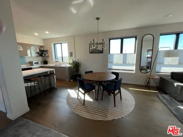 a kitchen with a dining table chairs and refrigerator