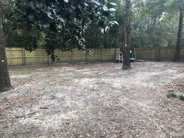 107 Kyle Lane Crestview, FL 32539 - Photo 23 of 25 a backyard of a house with a trees