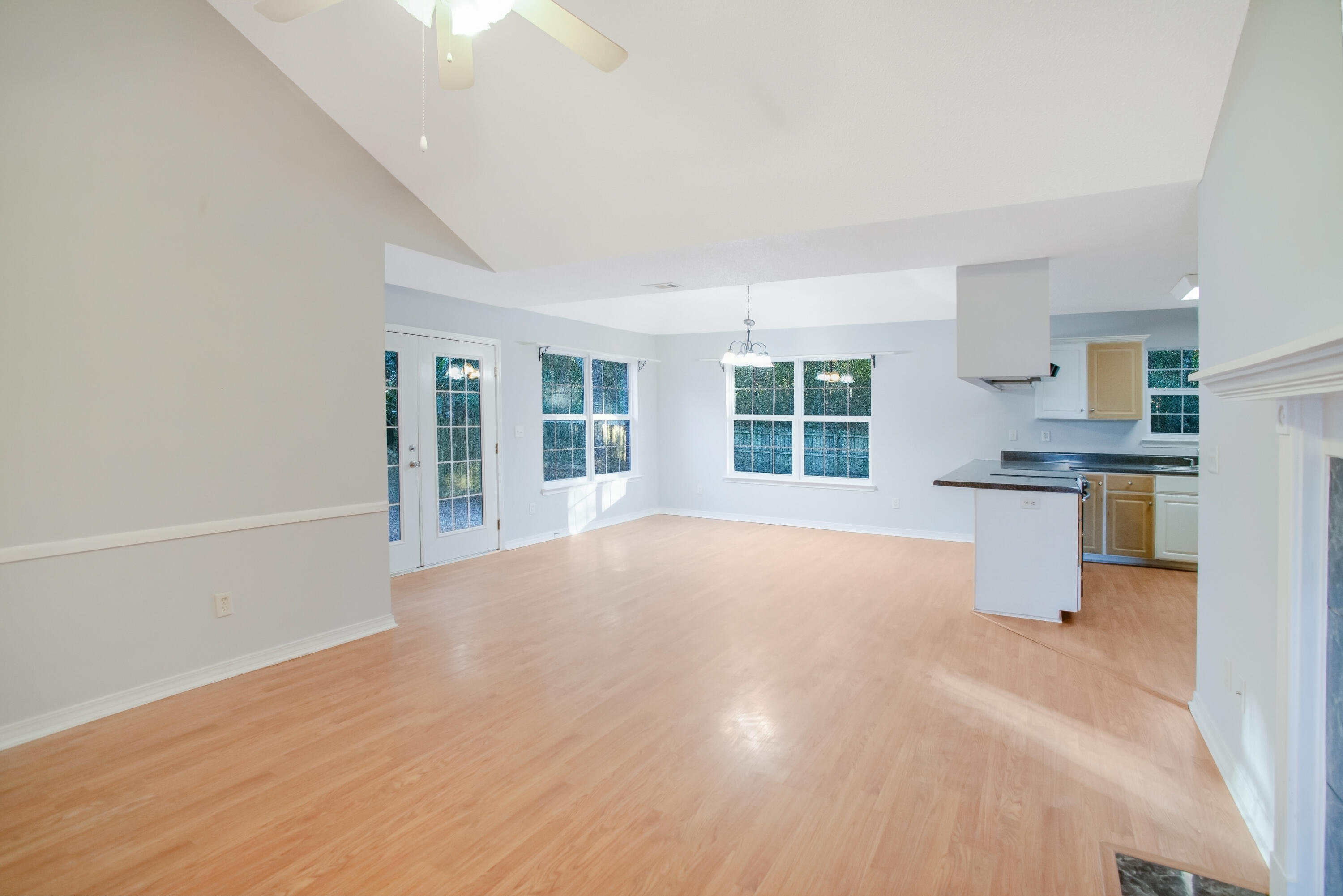 107 Kyle Lane Crestview, FL 32539 - Photo 5 of 25 an empty room with windows and a kitchen