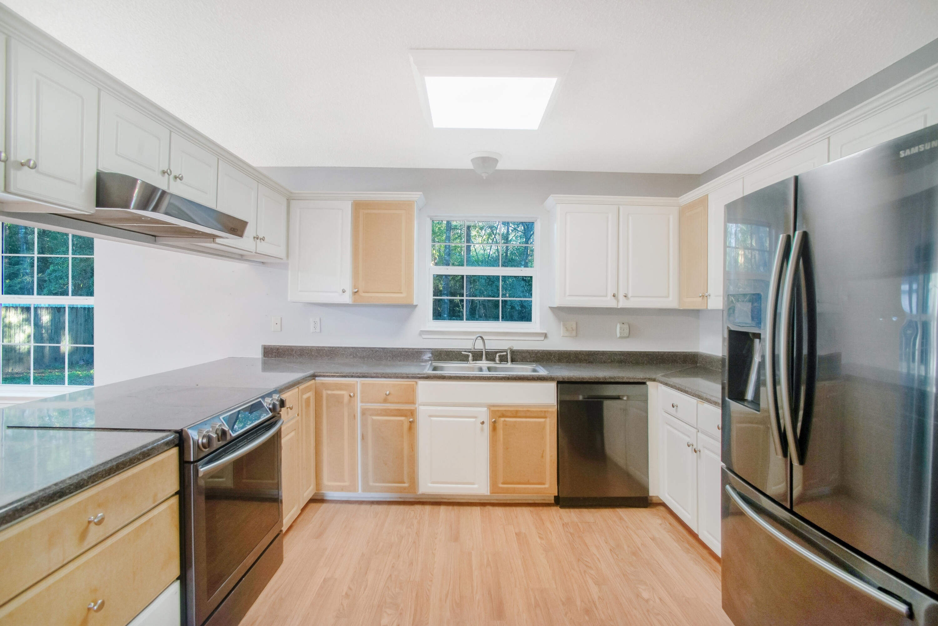 107 Kyle Lane Crestview, FL 32539 - Photo 6 of 25 a kitchen with granite countertop a refrigerator a sink dishwasher a stove and white cabinets with wooden floor