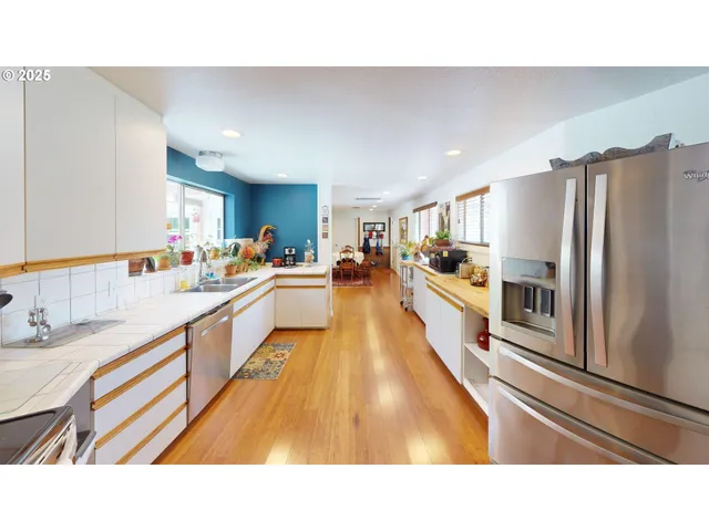 a open kitchen with stainless steel appliances a refrigerator and a sink